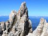 dolomiti-panorama-trek-latemar-trekking-in-val-di-fiemme-partendo-dallalpe-di-pampeago-esiste-tutta-una-serie-di-escursioni-da-un-giorno-sul-latemar-che-sono-raccordabili-in-un-trekking-lungo-fino-a-tre-giorni-si-pu-salire-innanzitutto-fino-alla-baita-caserina-per-godere-delle-opere-darte-di-respirart-la-galleria-darte-a-cielo-aperto-pi-alta-del-mondo-oltre-i-2000-metri-di-quota-da-qui-poi-si-taglia-in-quota-fino-alla-baita-passo-feudo-da-dove-comincia-lascesa-verso-la-celebre-torre-di-pisa-un-complesso-di-guglie-incredibili-vere-e-proprie-colonne-di-dolomia-che-sorreggono-il-cielo-della-valle-e-che-sprofondano-nel-vuoto-uno-spettacolo