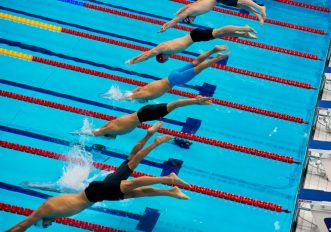 Tuffo dal blocco di partenza in piscinaTuffo dal blocco di partenza in piscina