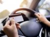 a-woman-holding-a-credit-card-shes-in-the-car-she-stops-filli