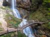cascata-di-tret-le-acque-cadono-a-piena-forza-tra-le-pareti-del-bosco-autunnale-mentre-le-foglie-dorate-e-rosse-creano-un-contrasto-caldo-e-vivido-attorno-al-salto