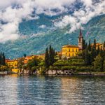 LAGO DI COMO – Le rive semi-deserte riflettono montagne nitide, mentre i borghi offrono caffè caldi e viste spettacolari sul lago in autunno.
