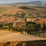 VAL D’ORCIA – Le colline si tingono di rame e oro, mentre borghi e vigne mostrano dettagli nascosti lontano dalla folla estiva.