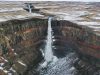 hengifoss-una-cascata-alta-e-stretta-che-scende-tra-colonne-basaltiche-rossastre-immersa-in-un-altopiano-spoglio-e-glaciale
