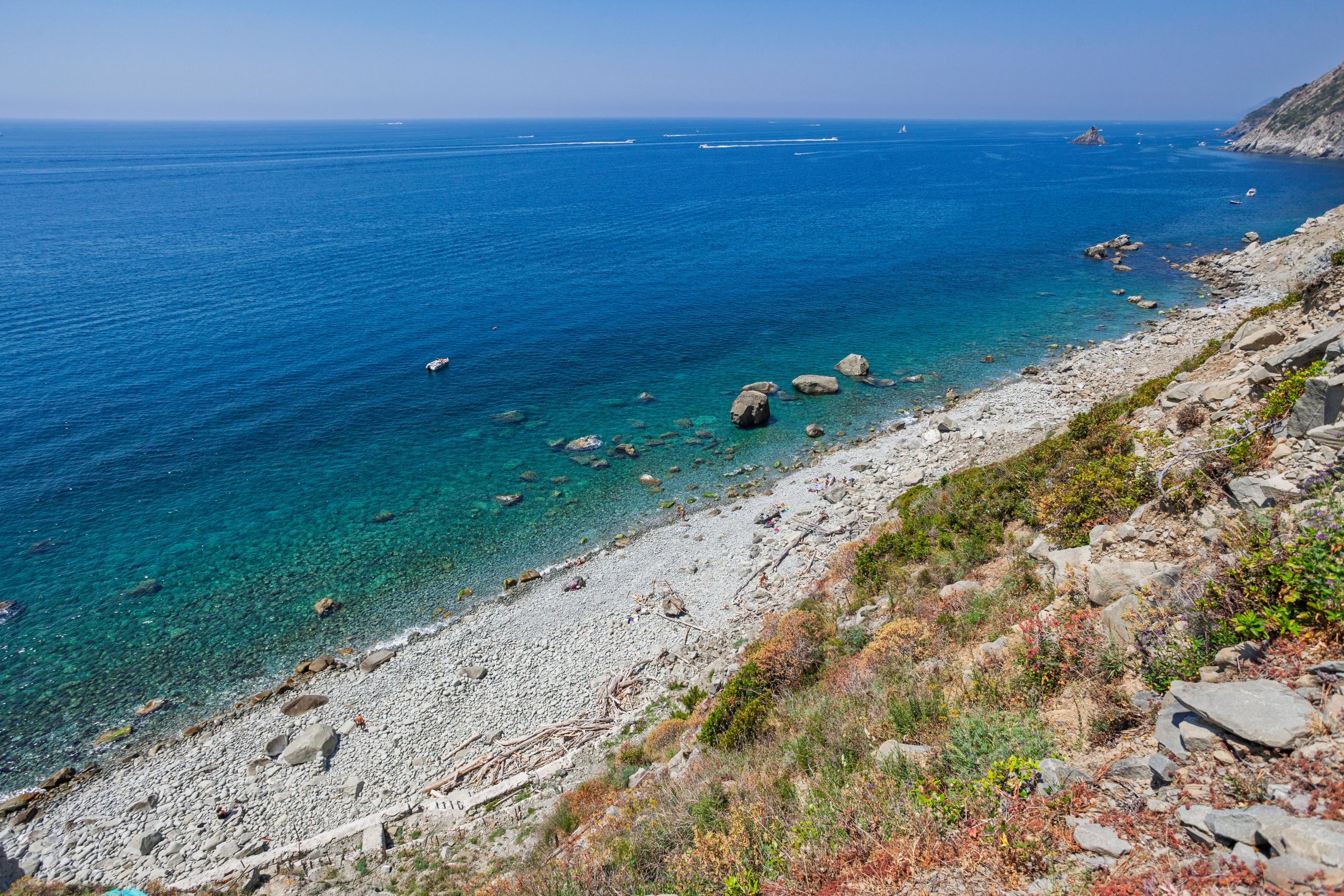 Bambini che giocano in acqua bassa e trasparente sulla spiaggia di Procchio