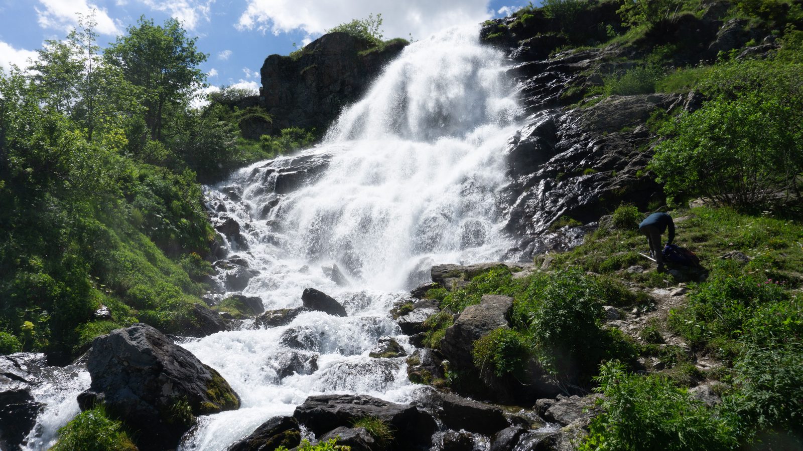 Cascata del Toce in primavera con getto d'acqua potente e vegetazione alpina