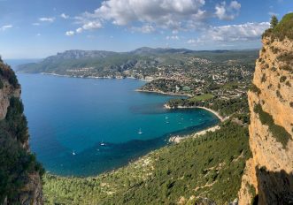 Scogliera rossa di Cap Canaille vista dal mare con cielo azzurro estivo
