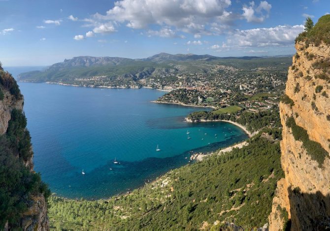 Scogliera rossa di Cap Canaille vista dal mare con cielo azzurro estivo