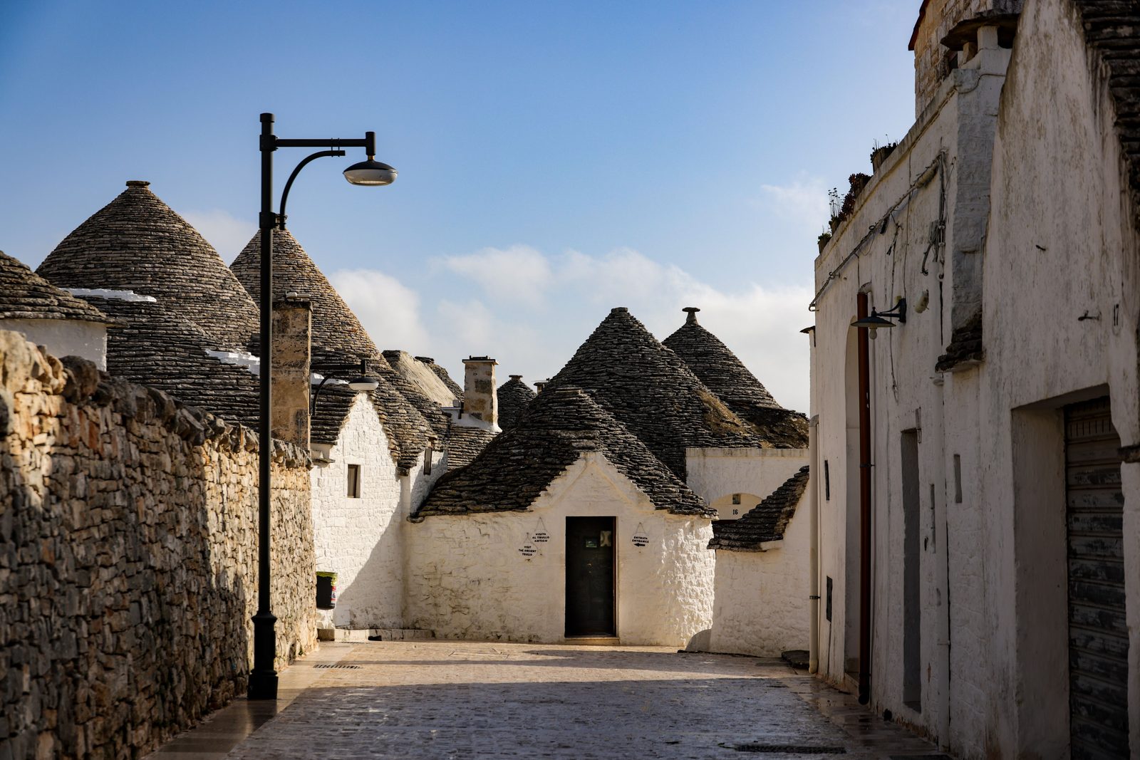 I trulli di Alberobello in Puglia sotto un cielo azzurro estivo