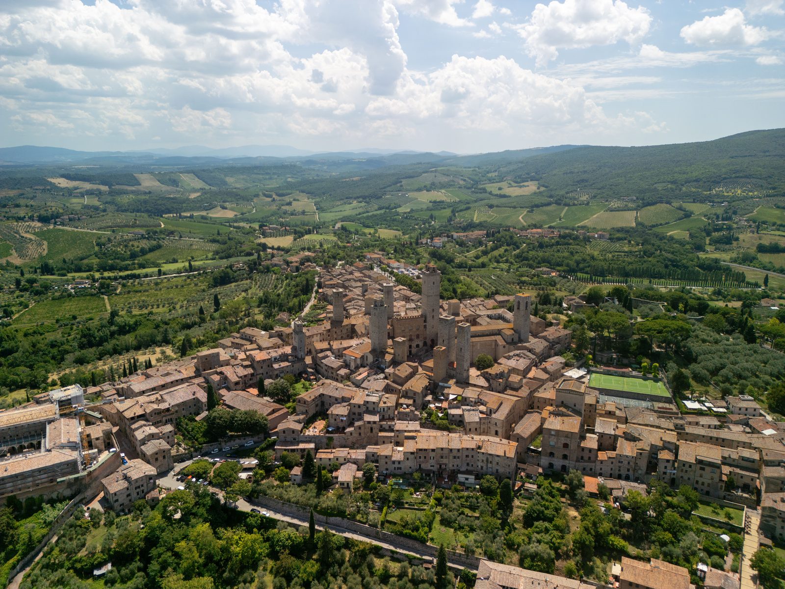 Veduta aerea di un borgo italiano storico patrimonio UNESCO tra colline verdi