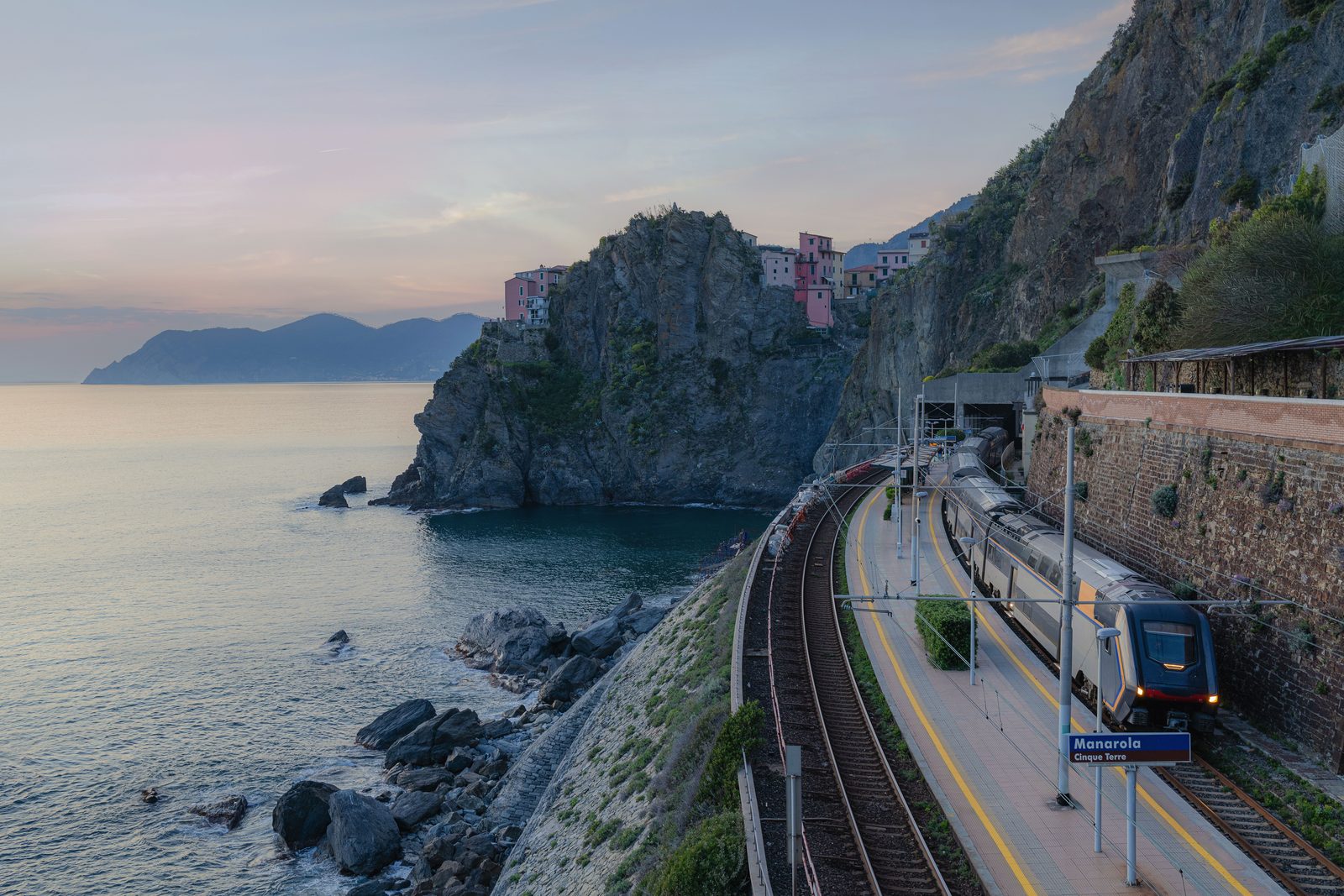 Treno regionale fermo alla stazione di un piccolo borgo costiero ligure Treno regionale fermo alla stazione di un piccolo borgo costiero ligure