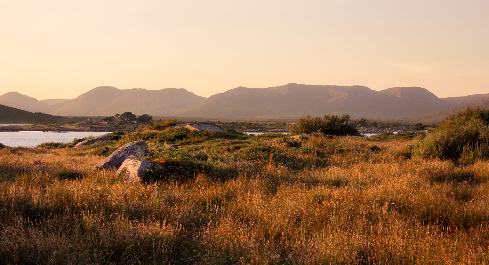 Paesaggio di torbiera e montagne del Connemara al tramonto con colori ramati Paesaggio di torbiera e montagne del Connemara al tramonto con colori ramati