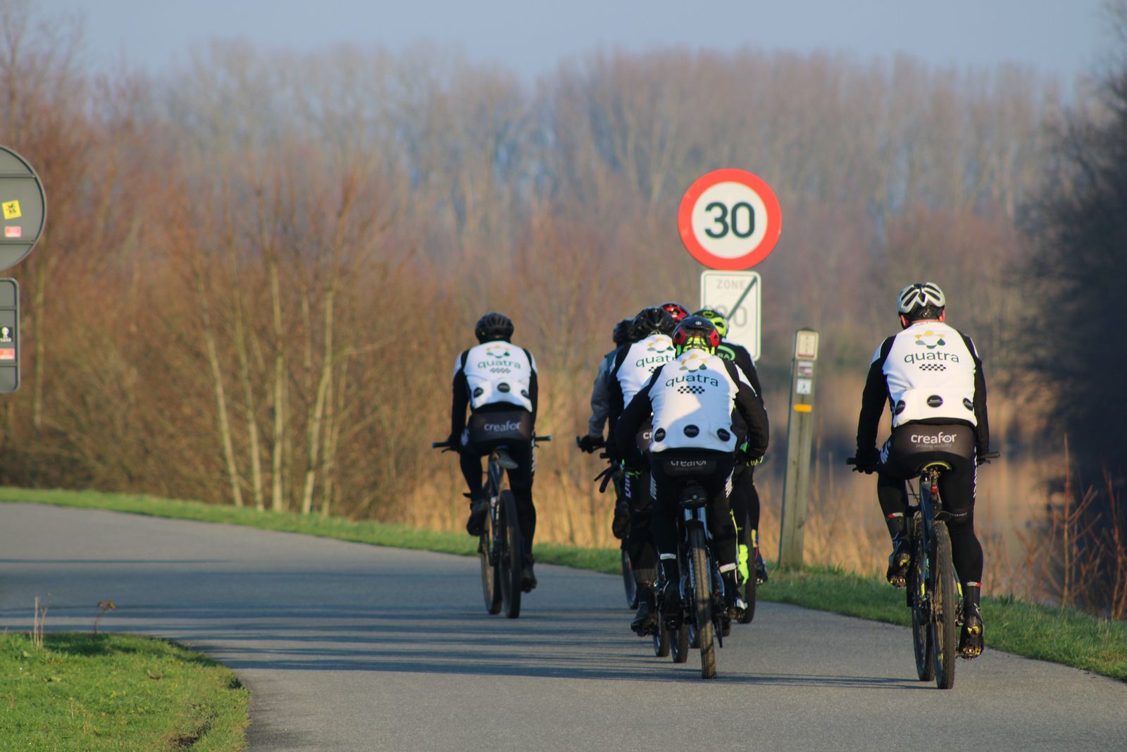 Ciclisti su pista ciclabile tra i polder fiamminghi Ciclisti su pista ciclabile tra i polder fiamminghi