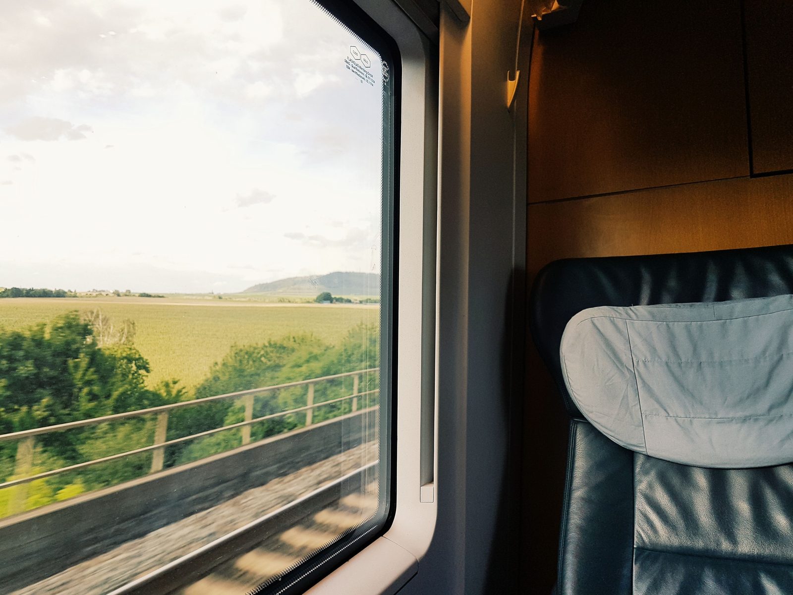 Interno di un vagone ad alta velocità con poltrona e finestrino sulla campagna francese
