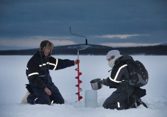 Ricercatori scientifici che estraggono carote di ghiaccio su un ghiacciaio artico