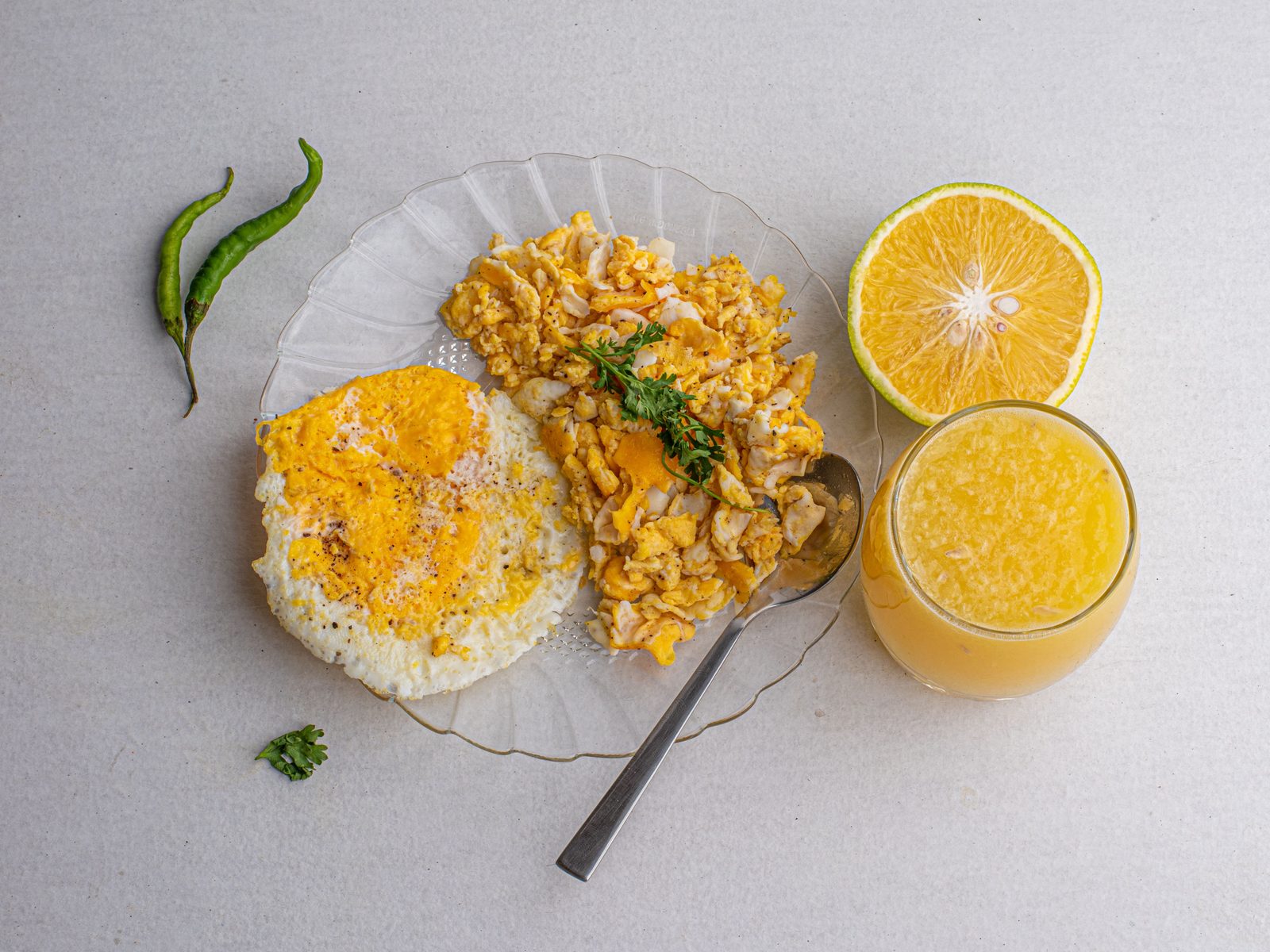 Colazione salutare con succo di arancia, uova e frutta fresca per combattere l'anemia