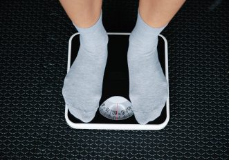 Uomo adulto sulla bilancia che monitora il peso e il metabolismo